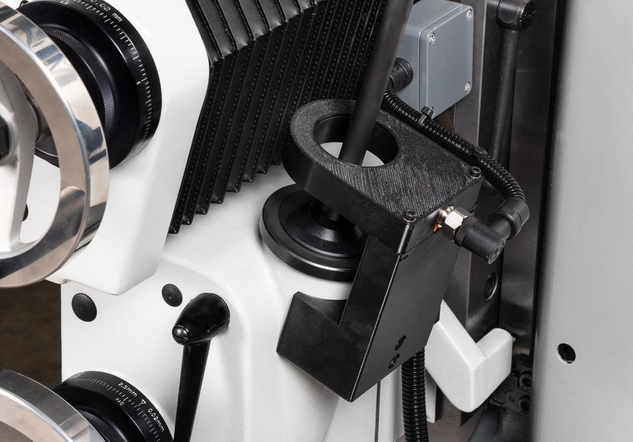 Nahaufnahme der elektrisch abgesicherten Abdeckkappe am Vorschubhebel; zeigt die Kappe, den Hebel und die Sensorik für die Nullstellung.