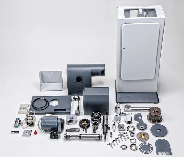 Einzelteile einer zerlegten Deckel S0E Stichelschleifmaschine, ordentlich nebeneinander platziert auf weißem Untergrund