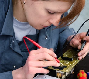 harich Elektrotechnikerin in Nahaufnahme lötet konzentriert an einer Platine