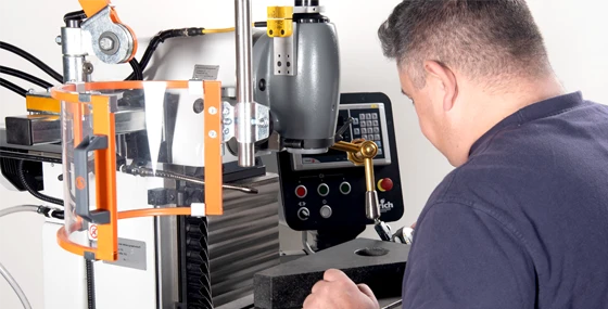 Zwei harich Techniker stehen seitlich an geöffneter Tür des harich Servicefahrzeugs, Mann lädt Koffer aus dem Fahrzeug